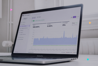 Close-up of a laptop on a white desk displaying the Modular DS uptime monitoring dashboard.