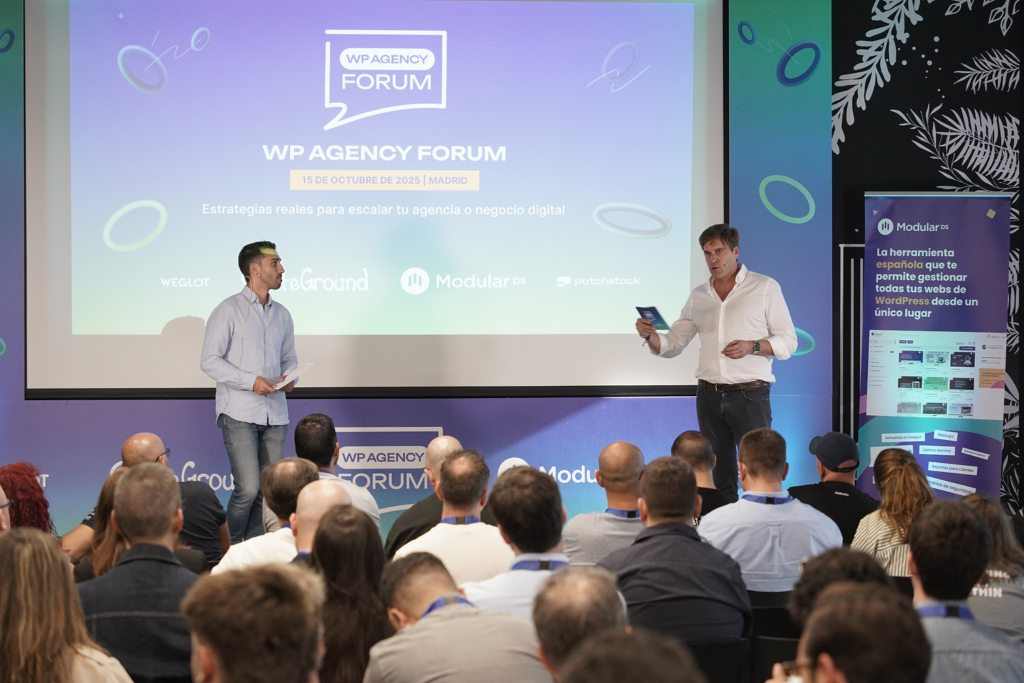 Héctor de Prada (Modular DS) y Juan Manuel Rodríguez (SiteGround) presentando en el escenario durante la apertura de WP Agency Forum 2025 en Talent Garden Madrid, con más de 150 profesionales y agencias de WordPress en el público.