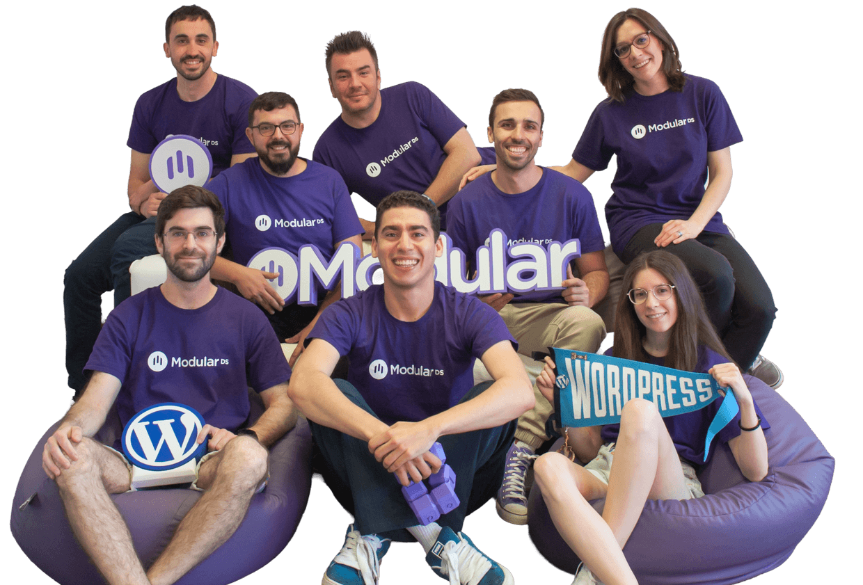 El equipo de Modular DS con camisetas moradas de Modular DS, sentados juntos y sonriendo.